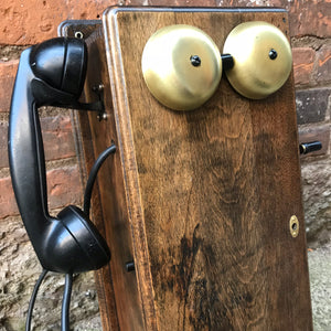 "Image: Antique 1900s Northern Electric Wall Mount Crank Wood Cabinet Telephone. A vintage wood cabinet telephone with intricate detailing, crank mechanism, and brass accents, capturing the essence of a bygone era and serving as a functional conversation piece and decorative treasure."